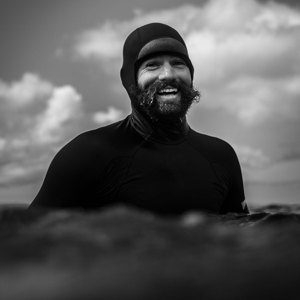 ivan florence wearing a hooded rashguard in black smiling at the camera